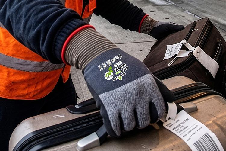 Arbeiter mit Schutzhandschuh bewegt Gepäck