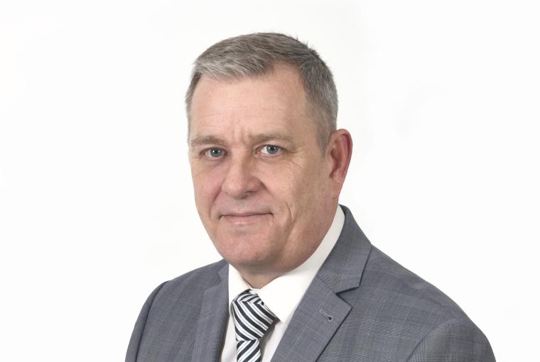 Mann mit grauen Haaren, grauem Sakko und gestreifter Krawatte