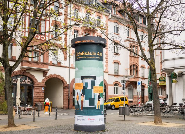 Advertising column in front of Wilhelminian-style facades
