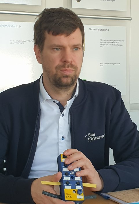 Head of Sales Germany bei Bihl+Wiedemann André Hartmann hält ein gemischte E/A-Feldmodule in der Hand
