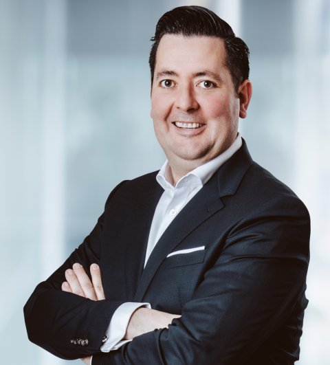 Carsten Simons mit verschränkten Armen vor weißem Hintergrund
