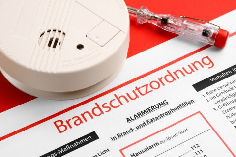 Rauchwarnmelder und Brandschutzordnung auf Papier