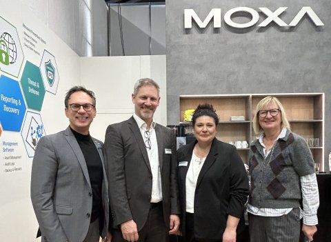 zwei Männer und zwei Frauen an einem Messestand