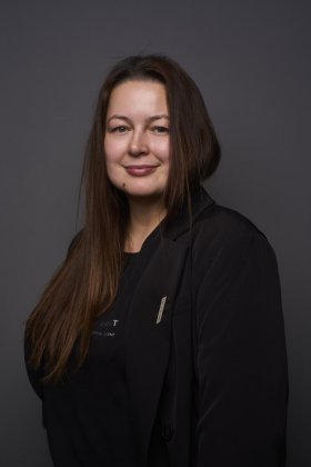 Brustbild einer Frau mit schwarzer Kleidung und langen Haaren