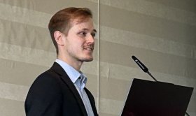 Junger Mann mit Teilbärtchen, Anzug und hellem Hemd