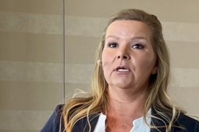 Junge Frau mit langen blonden Haaren beim Vortrag