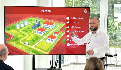 Mann zeigt eine Grafik am Monitor vor Publikum