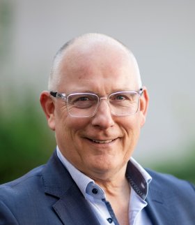 Mann mit Brille und blauem Sakko