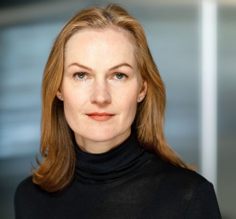 A young woman with long reddish hair and a black sweater