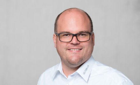Mann mit Halbglatze und dunkler Brille