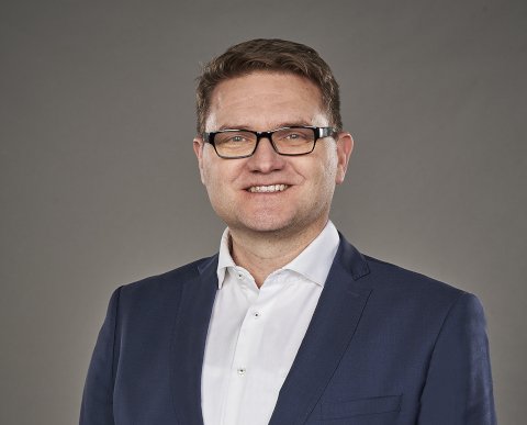 Jüngerer Mann mit Brille, blauem Anzug, Krawatte