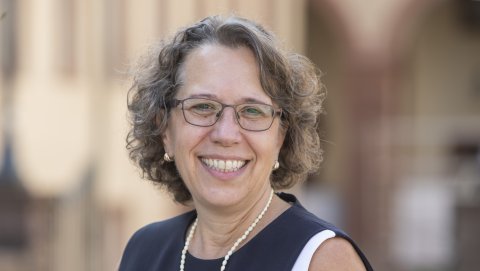 Frau mit Brille, schwarz-weißem Kostüm und Kette