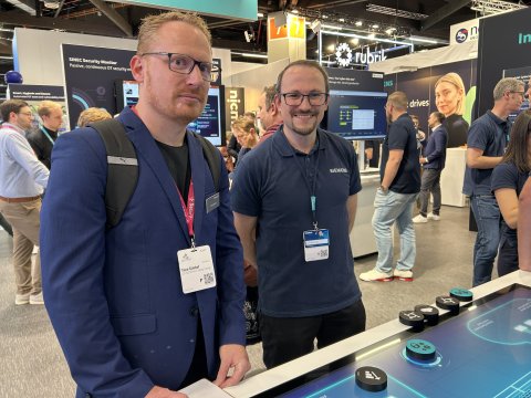 zwei junge Männer an einem Messestand