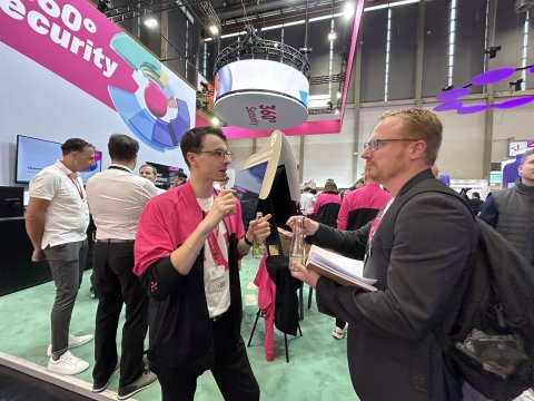 Junger Mann erklärt etwas vor einem Messestand